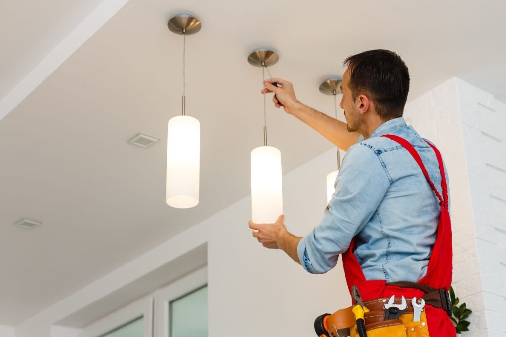 Electrician installing a pendant light in a Toowoomba home